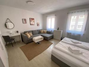 een woonkamer met een bank en een bed bij Swan Rooms in Neurenberg