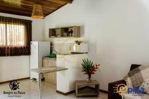 een keuken met een koelkast en een tafel in een kamer bij Bosque da Praia Flats in Pipa