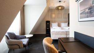 ein Hotelzimmer mit einem Bett, Stühlen und einem Tisch in der Unterkunft Hotel Old Dutch in Volendam
