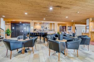 une salle à manger avec des chaises et une cuisine dans l'établissement Hôtel Cailler & Bains de la Gruyère, à Charmey