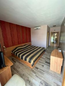 1 dormitorio con 1 cama y suelo de madera en HOTEL KREDO en Sliven