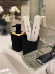 two black containers holding toothbrushes on a bathroom counter at LA CASA GRADSKI VRT modern family apartment with lockable bike storage in Osijek
