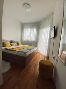 um quarto com uma cama e um banco em LA CASA GRADSKI VRT modern family apartment with lockable bike storage em Osijek