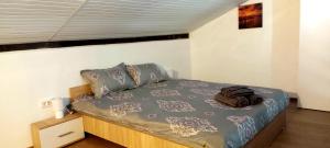 a bedroom with a bed with a blue comforter at Casuta de vacanta Miniș I in Miniş