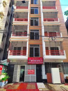 um edifício de apartamentos com varandas vermelhas e um hotel em White Rose Suites Ltd em Dhaka