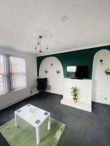 a living room with a white table and a tv at Stylish City Central Outskirts Sleeps 8 in Leeds
