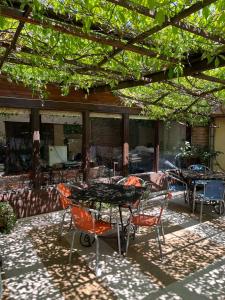 un patio avec des tables et des chaises sous une pergola dans l'établissement HOTEL KREDO, à Sliven