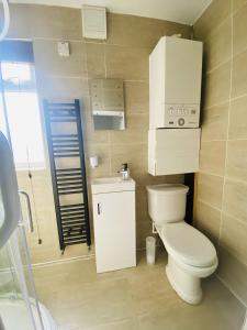 a small bathroom with a toilet and a sink at Stylish City Central Outskirts Sleeps 8 in Leeds
