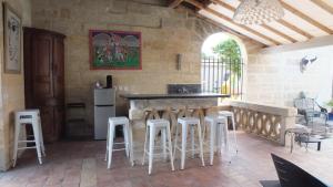 - une cuisine avec un comptoir et des tabourets dans une pièce dans l'établissement La Chapelle du Domaine de Choisy, à Abzac