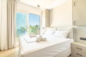 a bedroom with a large white bed with a view of the ocean at Luxury SeaSide Suites in Hersonissos