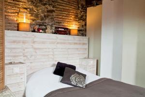 a bedroom with a bed and a brick wall at Loft charmant dans le centre historique in Nantes