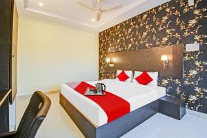 a bedroom with a large bed with red pillows at Capital O Ragas Inn in Hyderabad