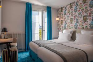 a hotel room with a bed and a window at Hôtel Edouard 6 by Malone in Paris