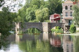 un puente de piedra sobre un cuerpo de agua en Gîte Léperon 2 en Clisson