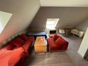 Cette chambre mansardée comprend un canapé, un lit et une table. dans l'établissement HOTEL KREDO, à Sliven