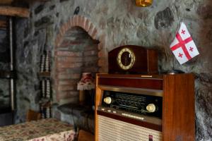 una antigua radio en una habitación con una pared de piedra en Kohi en Kazbegi