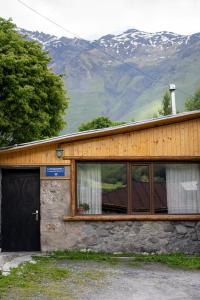 a building with a door and a mountain at Kohi in Kazbegi