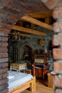 Habitación de piedra con cama y mesa en Kohi en Kazbegi