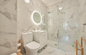 La salle de bains blanche est pourvue d'une douche et de toilettes. dans l'établissement Sunset Bay View, Renovated Apt, By TimeCooler, à Setúbal