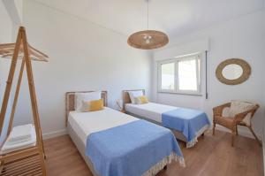 Cette chambre comprend 2 lits et une fenêtre. dans l'établissement Sunset Bay View, Renovated Apt, By TimeCooler, à Setúbal
