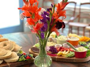 eine Vase mit Blumen auf einem Tisch mit Essen in der Unterkunft Luxury Farm Stay-Glenrose Cottage-Wolf Pine Hollow in Hancock