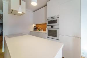 a kitchen with white cabinets and a white counter top at Apartament Delux Mountain Aparts in Świeradów-Zdrój +12 photos