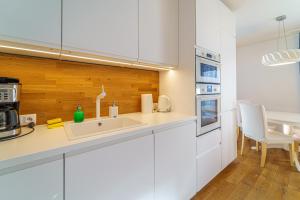 uma cozinha com armários brancos e um lavatório em Apartament Delux Mountain Aparts em Świeradów-Zdrój