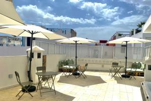 a patio with tables and chairs and umbrellas on a building at Dar Narjis in Asilah
