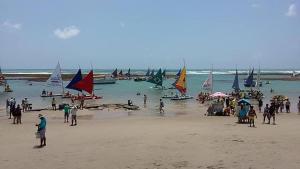a group of people on a beach with sail boats at Casa Siulan in Porto De Galinhas