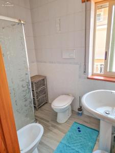 La salle de bains est pourvue de toilettes, d'un lavabo et d'une douche. dans l'établissement Wanderlust Sicily appartamento "Mare", à Oliveri