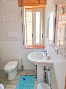 La salle de bains est pourvue d'un lavabo, de toilettes et d'une fenêtre. dans l'établissement Wanderlust Sicily appartamento "Mare", à Oliveri
