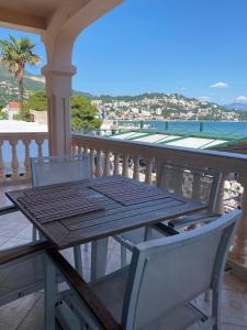 a wooden table and two chairs on a balcony at Apartments Grifone Lux in Herceg-Novi