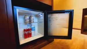 an open refrigerator with soda and water in it at Kojo Hotels Cebu-Mandaue in Mandaue City