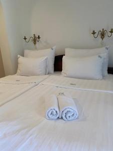 two towels sitting on top of a white bed at Apartments Grifone Lux in Herceg-Novi