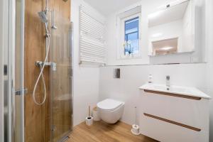 uma casa de banho com um chuveiro, um WC e um lavatório. em Apartament Ali-Leo em Gdynia