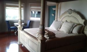 a bedroom with a large white bed with a canopy at Chateau la Mel in Mandeville