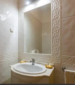 baño con lavabo y espejo grande en Algarve Luxury Apartment in Boavista Golf Resort, en Lagos