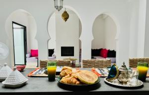 a table with a plate of bread and orange juice at Dar Narjis in Asilah