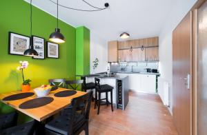 a kitchen and dining room with green walls and a wooden table at RELAX PARK Třeboň I in Třeboň