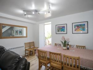 a dining room with a table and chairs and a couch at Maes Y Ffynnon in Pwllheli