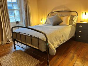 a bedroom with a bed with a metal frame and pillows at 5 Castle Hill in Lancaster