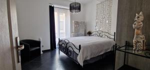 um quarto com uma cama e uma cadeira em L'oiseau du paradis em Narbona