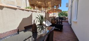 a balcony with a wooden deck with umbrellas at L'oiseau du paradis in Narbonne