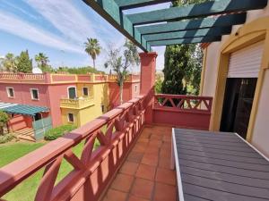 a balcony of a house with a wooden railing at 2 Piscinas en Isla Canela in Huelva