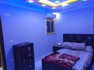 a bedroom with a bed and a blue wall at شقه فندقيه in Cairo