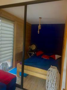 1 dormitorio con 1 cama con pared azul en Domek ,, Daglezja ”, en Dziwnów