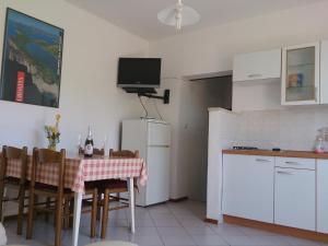 a small kitchen with a table and a refrigerator at Apartments Valentino in Rab