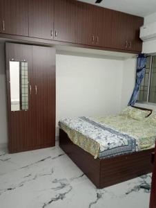 1 dormitorio con 1 cama, armarios y suelo de mármol en Variyar Service Apartments Unit D 2nd Floor en Vellore