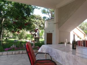 a table with two chairs and a bottle of wine at Apartments Valentino in Rab