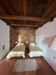 two beds in a room with a brick wall at Apartments Jezerce 28 in Jezerce